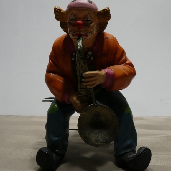 CLOWN porcelain sitting on bench playing saxophone